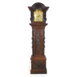 A 19th century carved oak long case clock the arch pediment over the brass face with phase of the