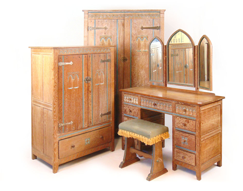 An Arts and Crafts limed oak bedroom suite comprising of ladies wardrobe, gentleman's wardrobe,