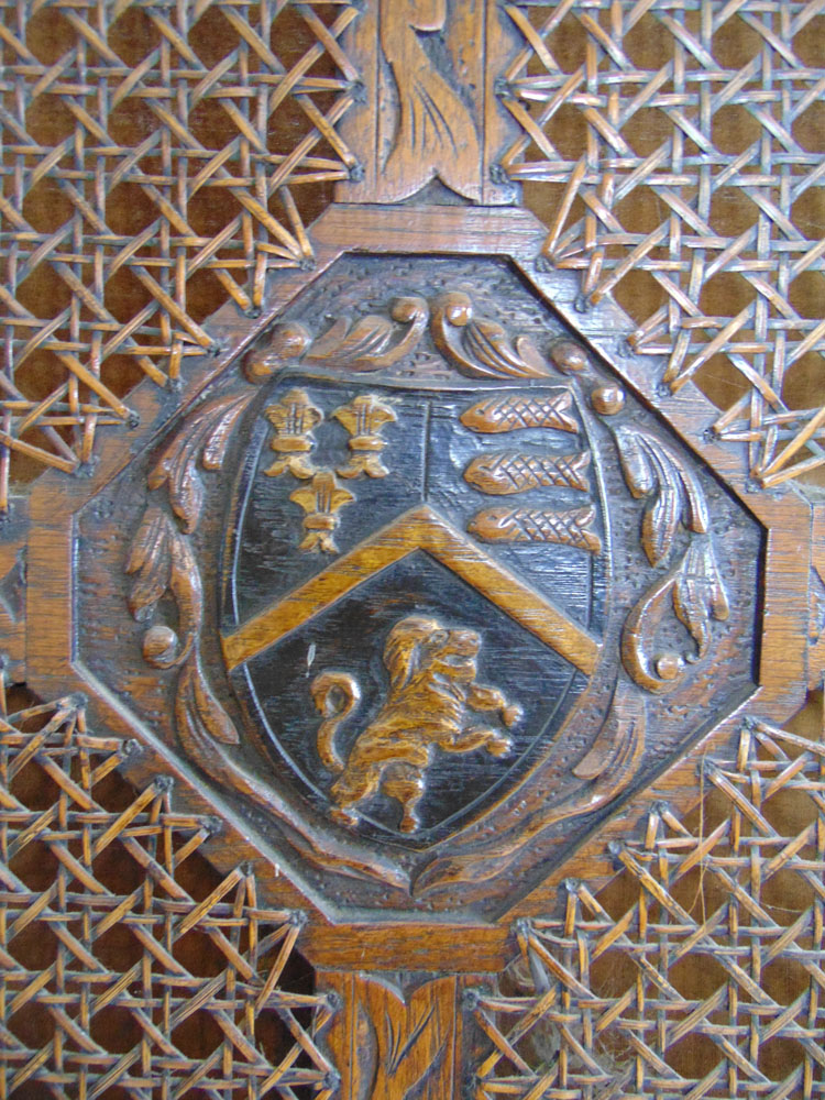 A 19th century carved oak four fold screen with cane surrounding a carved armorial crest over - Image 2 of 4