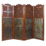 A 19th century carved oak four fold screen with cane surrounding a carved armorial crest over