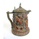 A 19th century copper and brass bacchanalian lidded tankard profusely decorated with raised scenes