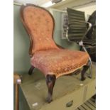 A Victorian walnut nursing chair upholstered in a button back pink floral fabric