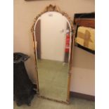 An ornate arch topped bevel glass mirror