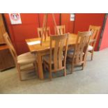 A modern oak extending dining table along with a set of six matching chairs