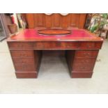 A reproduction mahogany twin pedestal desk with burgundy tooled leather insert to top