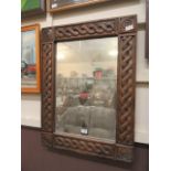 A carved wooden framed wall mirror