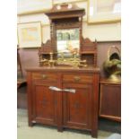 An Edwardian walnut sideboard having a raised mirrored back with the base having two drawers above