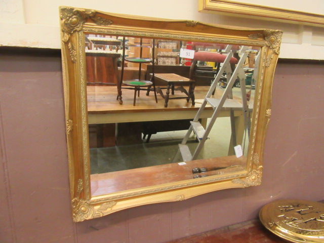 An ornate gilt framed bevel glass wall mirror