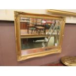 An ornate gilt framed bevel glass wall mirror
