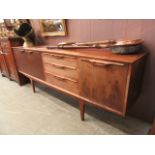 A mid-20th century design teak sideboard having a pair of cupboard doors with three drawers with
