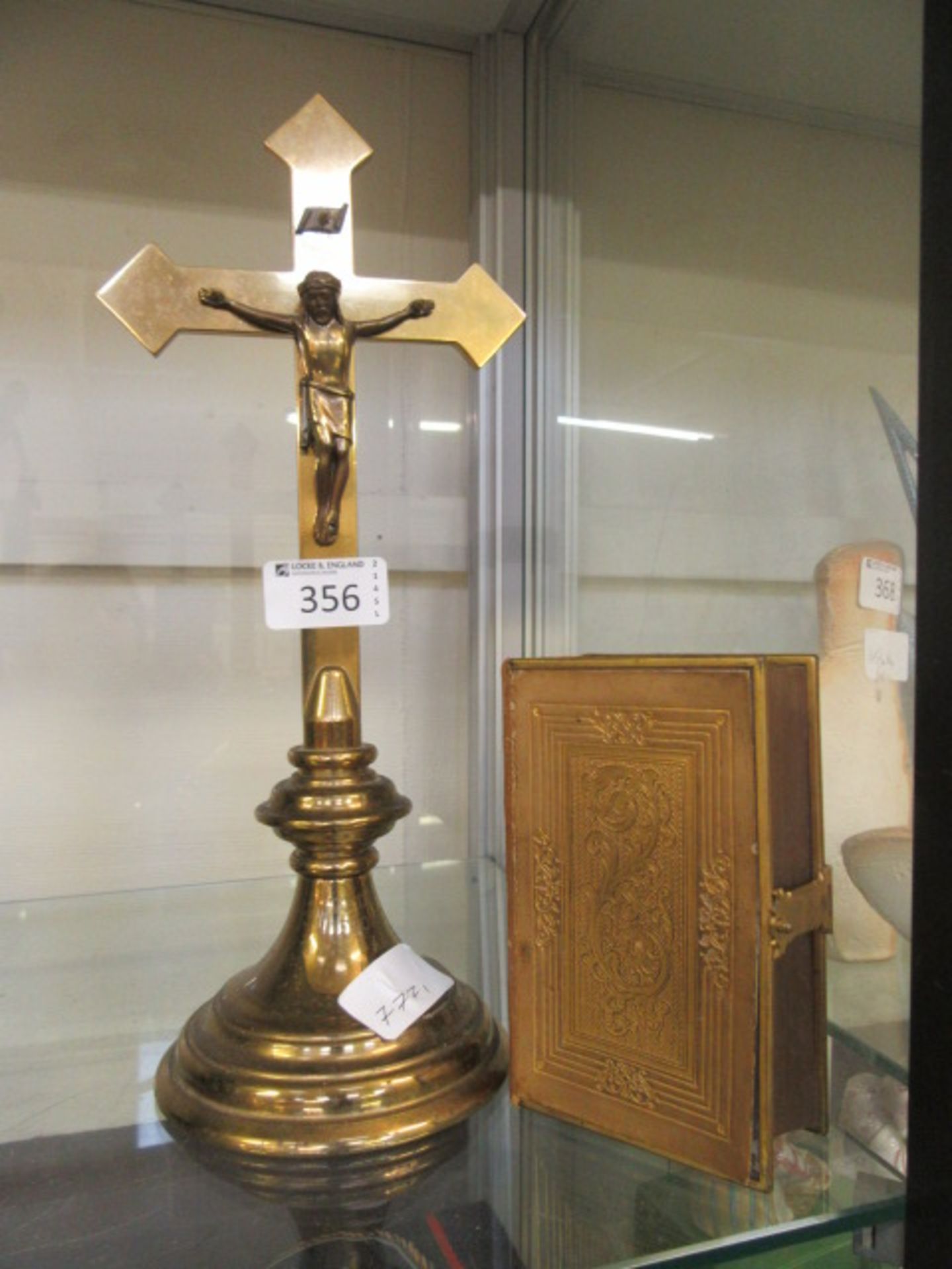 A brass crucifix along with a church services book