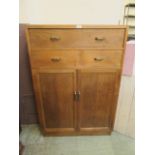 A mid-20th century gentleman's tall boy having two drawers above cupboard doors