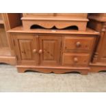 A waxed pine cabinet having two cupboard doors with two small drawers