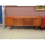 A mid-20th century design sideboard having an assortment of three drawers and cupboard doors