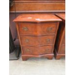 A reproduction burr elm serpentine fronted chest of three drawers of small proportions