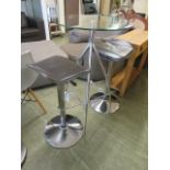 A modern high chrome based glass topped table along with a set of two matching stools