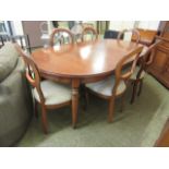 A modern cherry wood extending dining table along with a set of six matching chairs