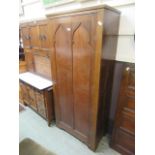 A 19th century oak hall robe with arched panel door