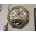 An embossed brass octagonal bevel glass mirror