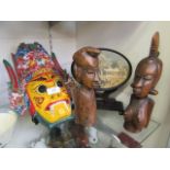 A painted mask together with two carved African figures and one cork carved plaque