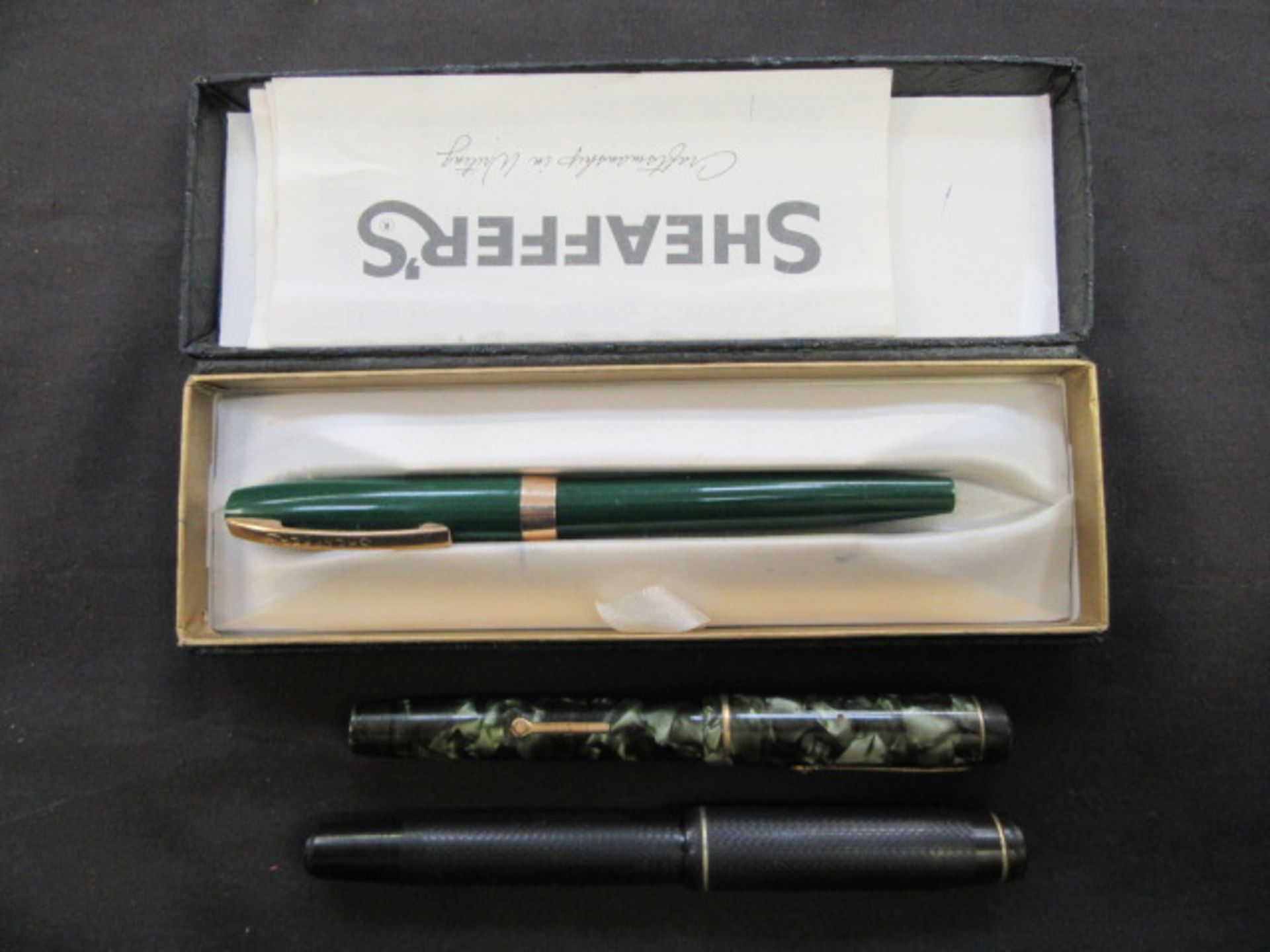 A bag containing a cased green Schafer pen together with two fountain pens