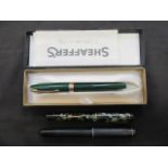 A bag containing a cased green Schafer pen together with two fountain pens