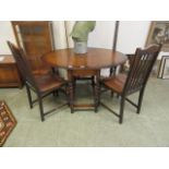 An early 20th century oak drop leaf table along with two chairs