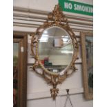 A modern ornate gilt metal framed oval bevel glass mirror