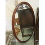 An early 20th century walnut oval bevel glass mirror