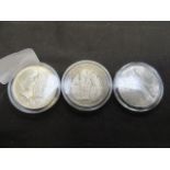 Three white metal coins