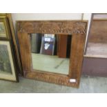 A carved framed square mirror