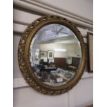 A reproduction circular gilt wood bevel glass mirror