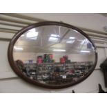An early 20th century mahogany and strung oval bevel glass mirror