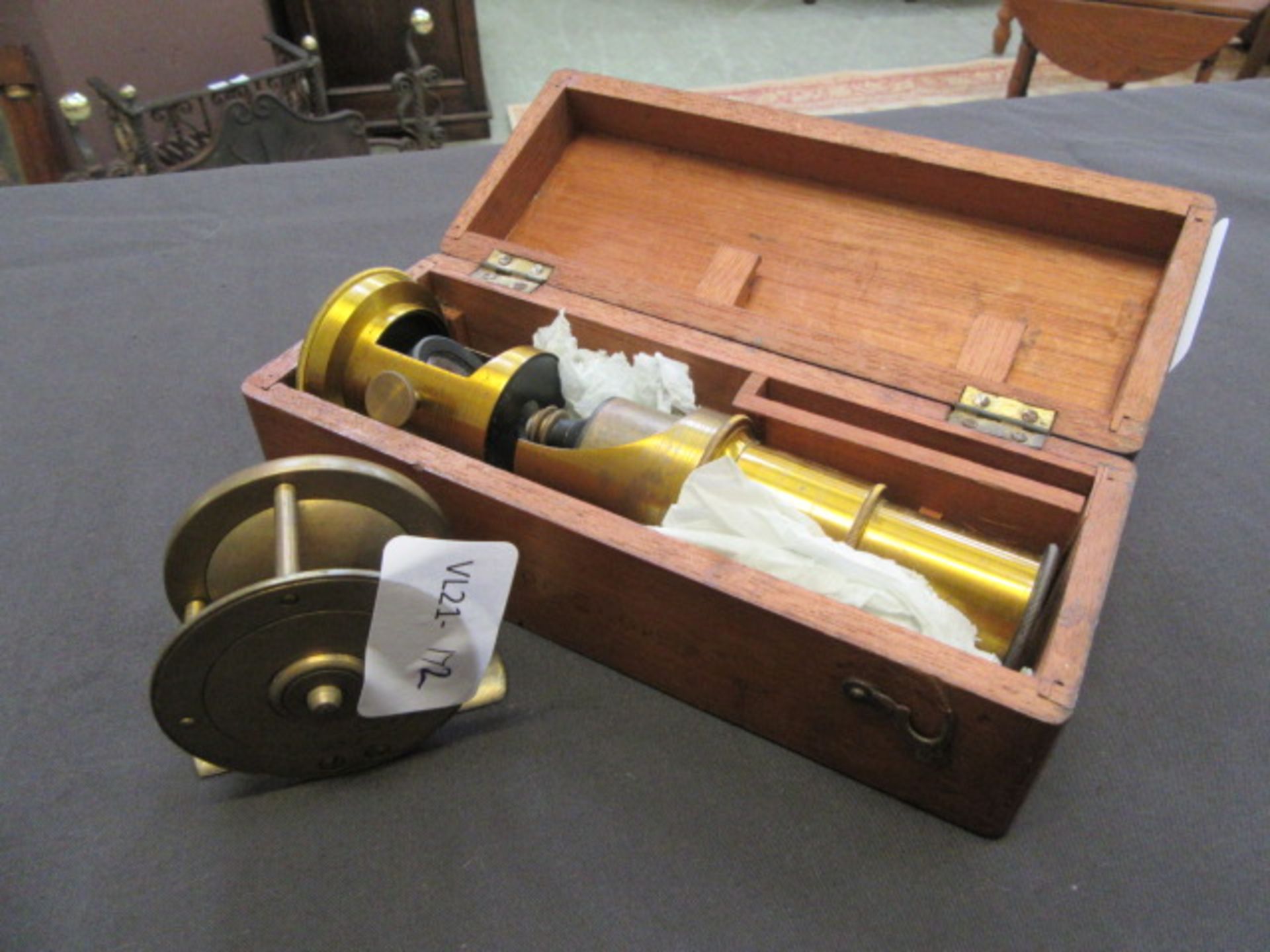 An early 20th century telescope in mahogany box together with a brass fishing reel