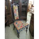 An early 20th century stained oak barley twist back church chair having needlework to the back and