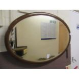 An early 20th century mahogany and strung oval bevel glass mirror