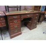 An early 20th century oak twin pedestal desk with green tooled leather insert to top