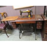 A Singer sewing machine in table with treadle base