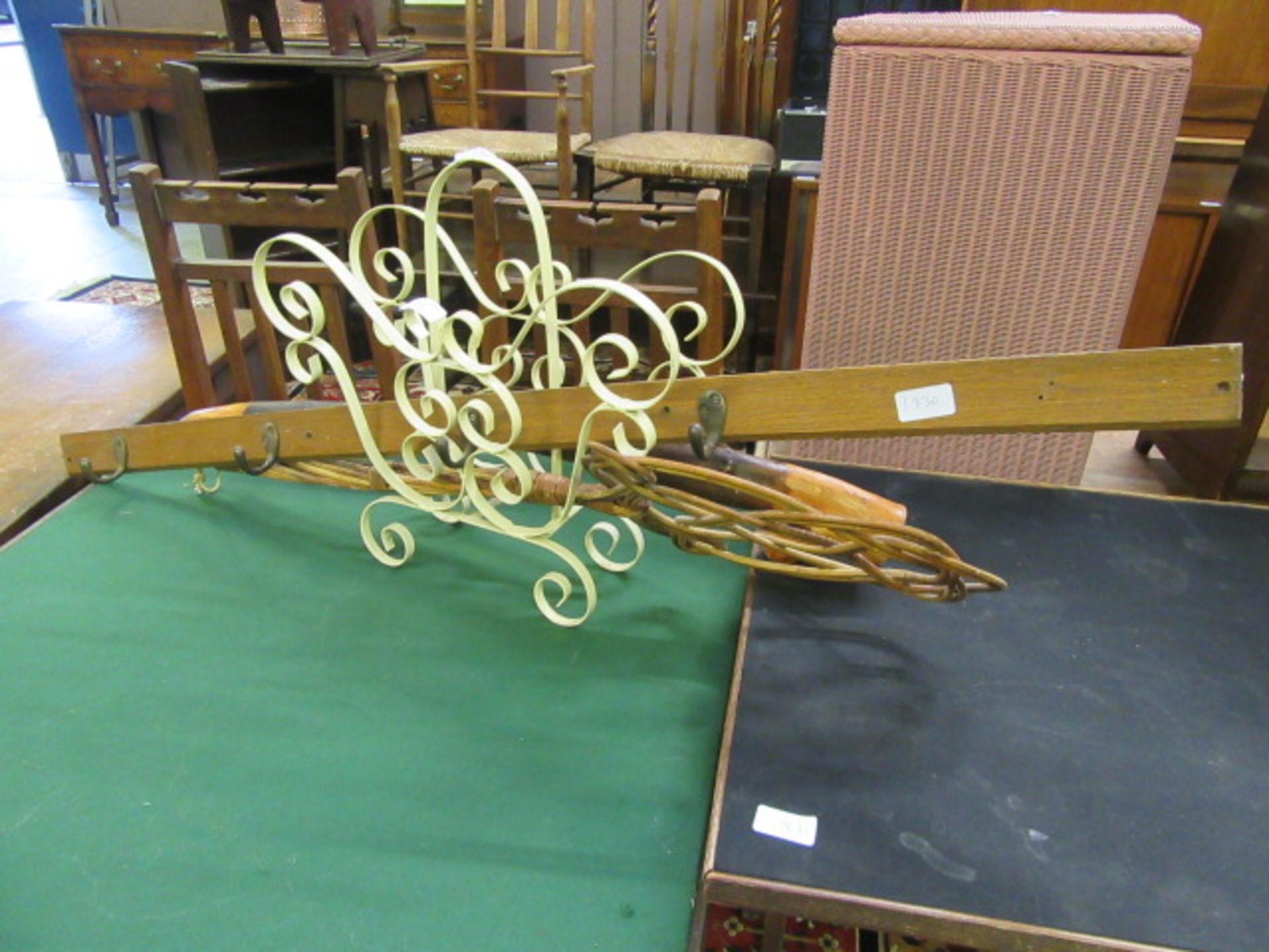 A cream painted metal magazine rack together with a carpet beater,