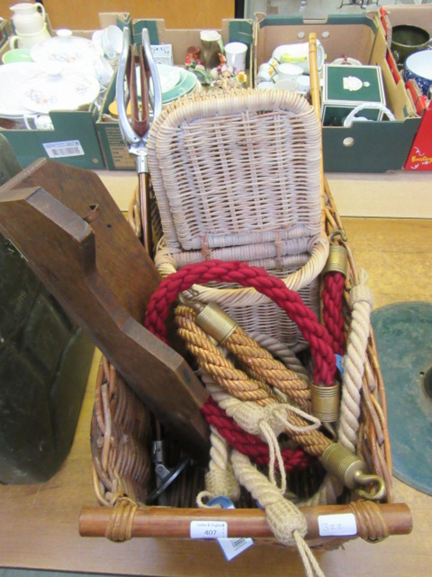 A wicker basket containing shooting stick, walking cane, rope etc.