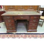 An early 20th century oak twin pedestal desk with green tooled leather insert to top
