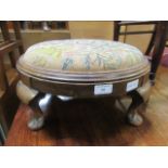 An early 20th century walnut foot stool with four cabriole legs and a needlework seat