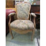 An early 20th century walnut framed open arm chair with needle work back,