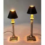 DINING TABLE LAMPS, two matching silvered Corinthian capped columns and stepped bases (with shades),