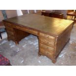 PARTNER'S DESK, George III style walnut with a green leather and gilt tooled top above nine