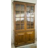 BOOKCASE, George III oak, the glazed upper section with adjustable shelves above a base with brown