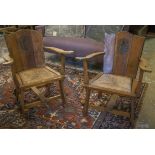 OPEN ARMCHAIRS, a pair, Arts and Crafts oak with armorial carved backs and rush seats, 79cm H x 71cm