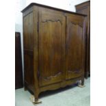 ARMOIRE, Louis XV oak with two panelled doors enclosing plank shelves, 135cm W x 167cm H x 60cm