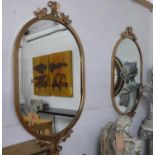 WALL MIRRORS, a pair, 1950's Italian style, gilt metal framed with oval plates, 112cm H x 64cm. (2)