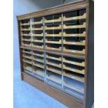 HABERDASHERY CABINET, mid 20th century oak by Pollards with four sliding glazed doors enclosing 36